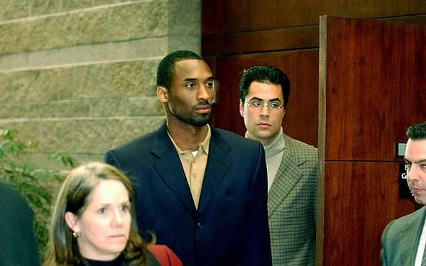 Image of Caption: Kobe Bryant arrested and charged with sexual assault and false imprisonment after a 19-year old woman alleged he raped her in a local hotel room
